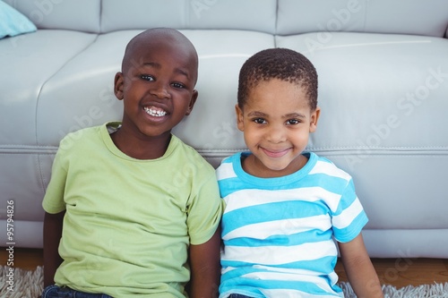 Smiling kids sitting by the couch