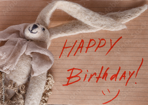 Felt doll on background with message Happy birthday photo