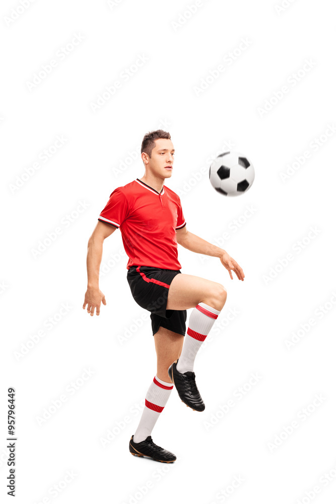 Young football player juggling a ball