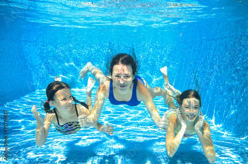 Family swim in pool underwater, happy active mother and children have fun in water, kids sport on family vacation
