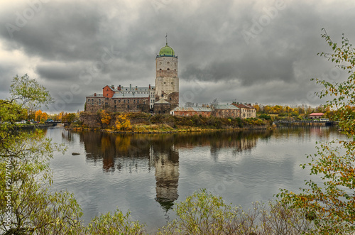 A view of Zamkovy Island and the castle with the reflections on the water at the cloudy autumn day in Vyborg 
