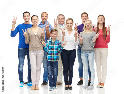 group of smiling people showing peace hand sign