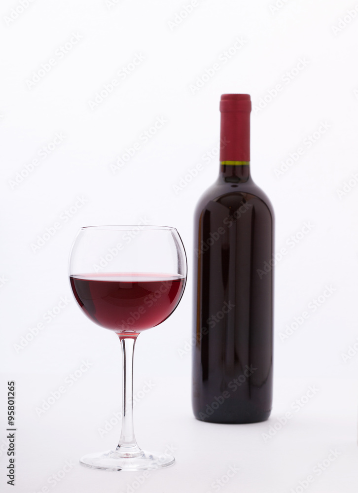 Glass and bottle of red wine unusually on white background. Glass and bottle of red wine unusually on white background.