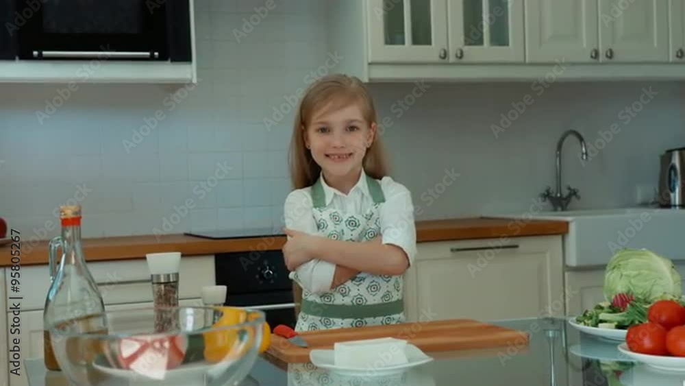 Girl chef in the kitchen looking at camera and smiling Girl chef in the kitchen looking at camera and smiling