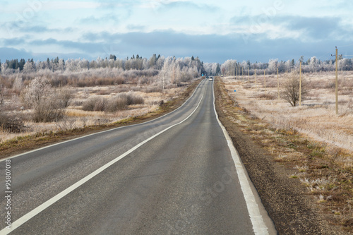 Winter landscape with the highway going through fields