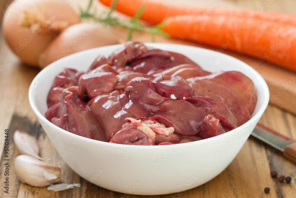 chicken liver in white bowl with carrot, garlic and onion chicken liver in white bowl with carrot, garlic and onion