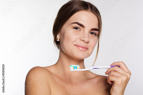 Teen girl is holding teeth brush with toothpaste