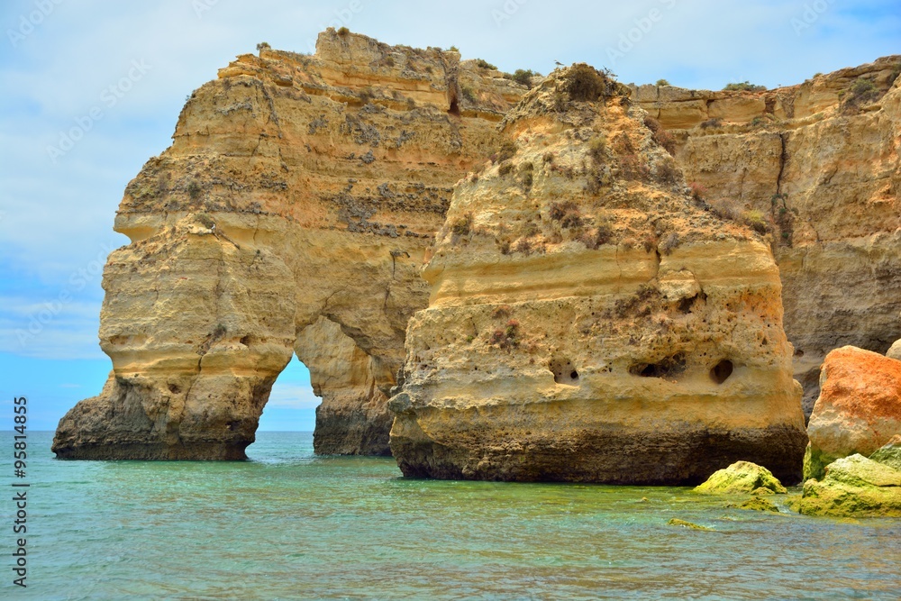 Atlantic ocean coast in the Algarve, azure ocean water and huge rocks and cliffs