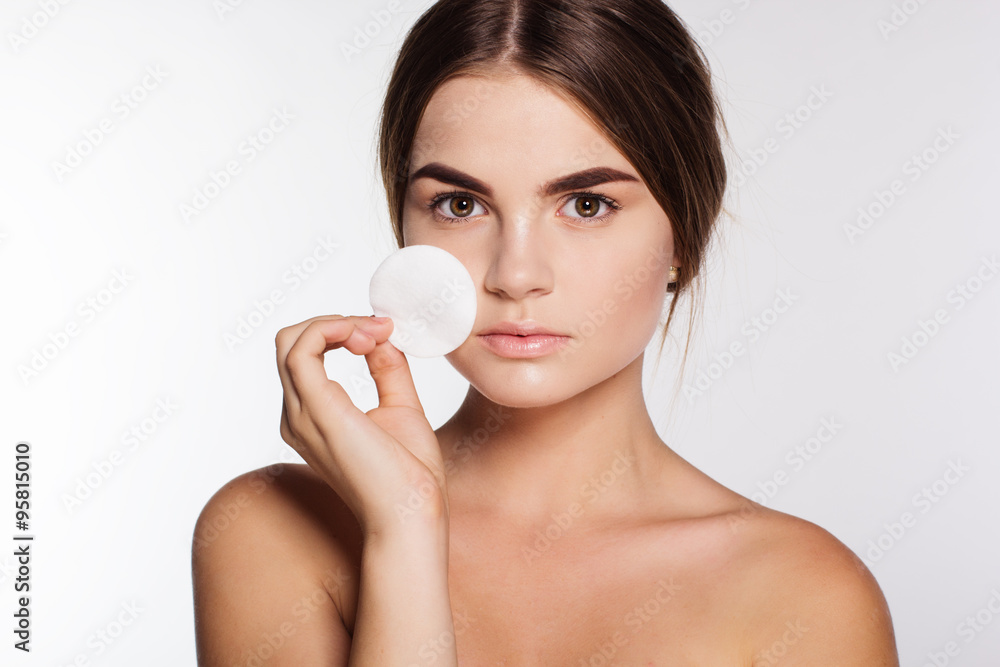 Teen girl is cleaning face with cotton wool Teen girl is cleaning face with cotton wool