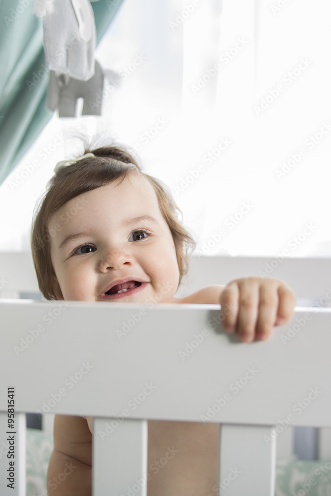 Infant baby resting and playing in his little baby bed Infant baby resting and playing in his little baby bed