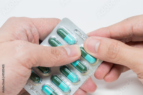 Obraz na plátně Close up of man's hand taking out pills from blister pack