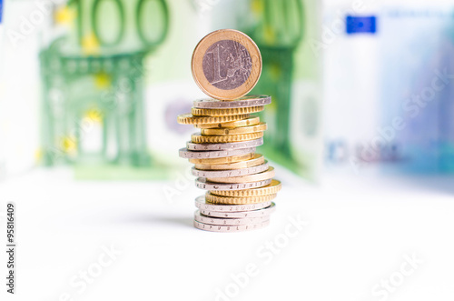 Buildings of Euro money on a top is coin. Background from euro banknotes. Isolated. Currency photo