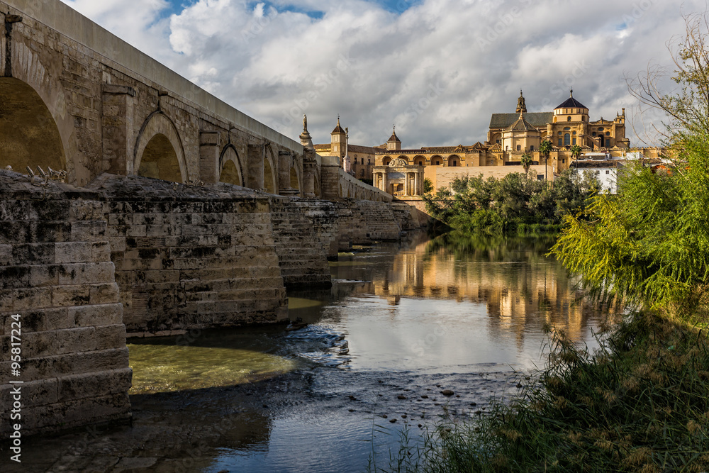 In the foreground the Guadalquivir river, with the Roman Bridge. In background the Mosque-Cathedral. Cordoba. Spain.