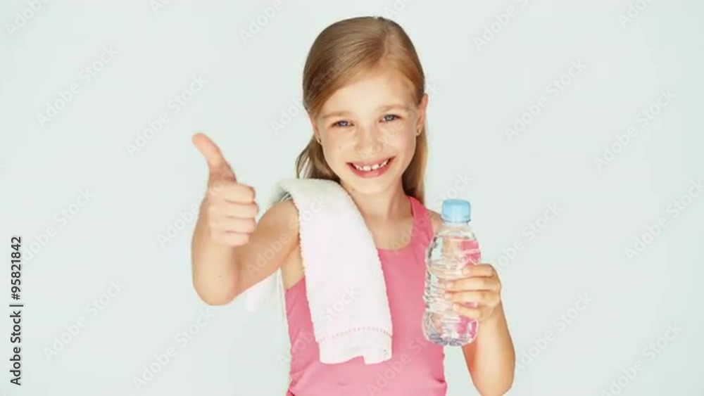 Girl child sportsman showing bottle of water. Thumb up. Ok Girl child sportsman showing bottle of water. Thumb up. Ok