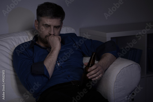 Man drinking beer at home
