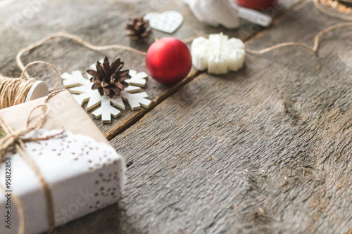 Cozy vintage toned winter holidays Christmas Composition with Gifts Boxes and Balls, Pine Cones Wooden Background