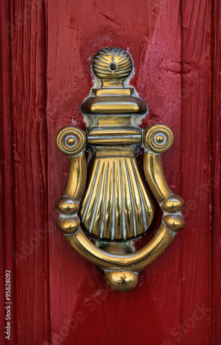 Close-up details of a golden door knocker in Malta.