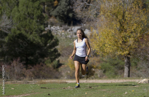 Mujer joven corriendo por el campo en ooño