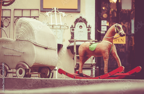 Fotografie Retro baby carriage and toy rocking-horse antique sale
