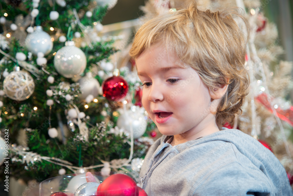Little boy with Christmas ornaments.