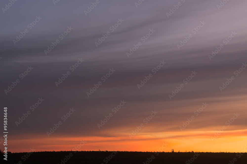 Moody clouds sweeping across a peach sunset in the country Moody clouds sweeping across a peach sunset in the country