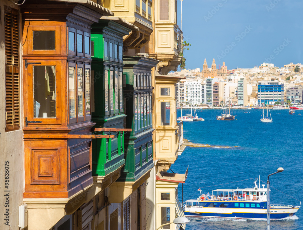 Brown, Green, Yellow balconies of Valletta with the view of Malta and tourist boat, Malta