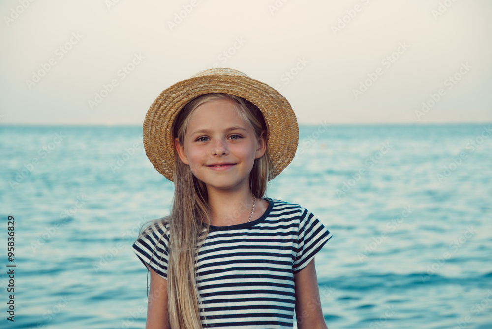 Счастливая девочка на море в соломенной шляпке.  