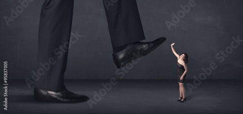 Giant person stepping on a little businesswoman concept