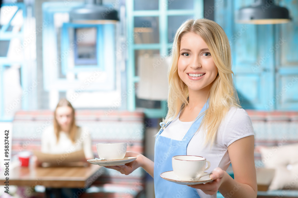Pleasant waitress holding cup Pleasant waitress holding cup