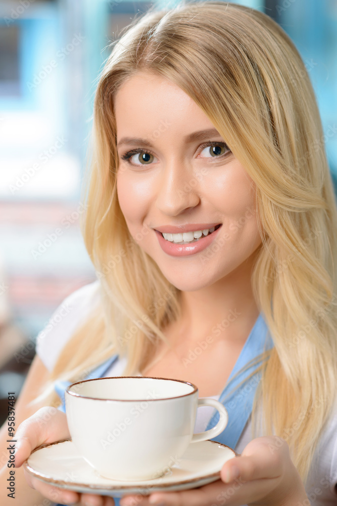Pleasant waitress holding cup Pleasant waitress holding cup