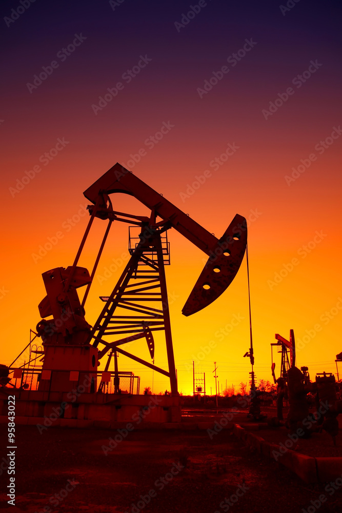 Oil field scene, the evening of beam pumping unit in silhouette Oil field scene, the evening of beam pumping unit in silhouette