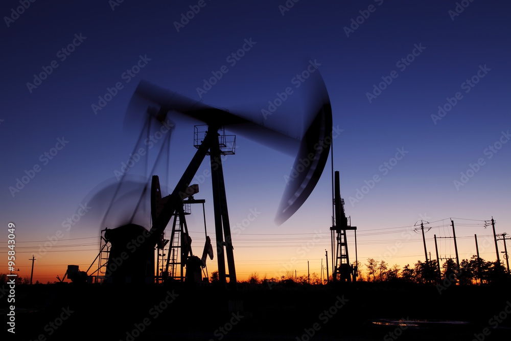Oil field scene, the evening of beam pumping unit in silhouette Oil field scene, the evening of beam pumping unit in silhouette