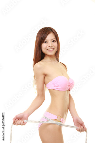 young Japanese woman measures her hip