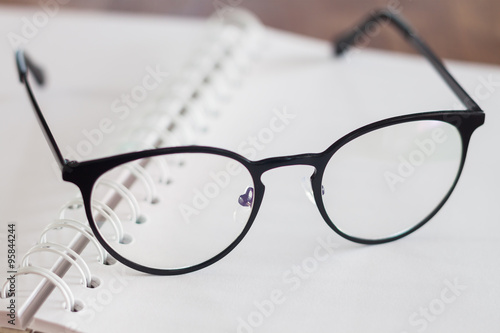 Eyeglasses on opened spiral notebook