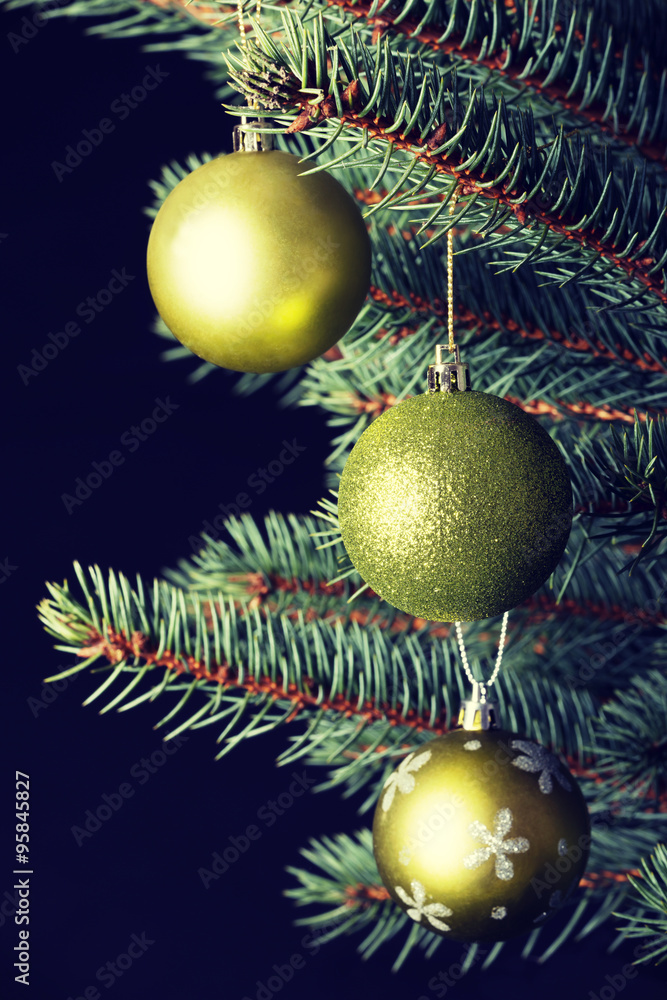 Three christmas balls hanging on a twig.