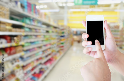 hand hold smartphone with supermarket background