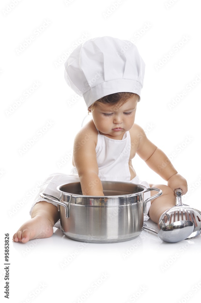 Funny adorable baby boy chef sitting and playing with kitchen equipment Funny adorable baby boy chef sitting and playing with kitchen equipment
