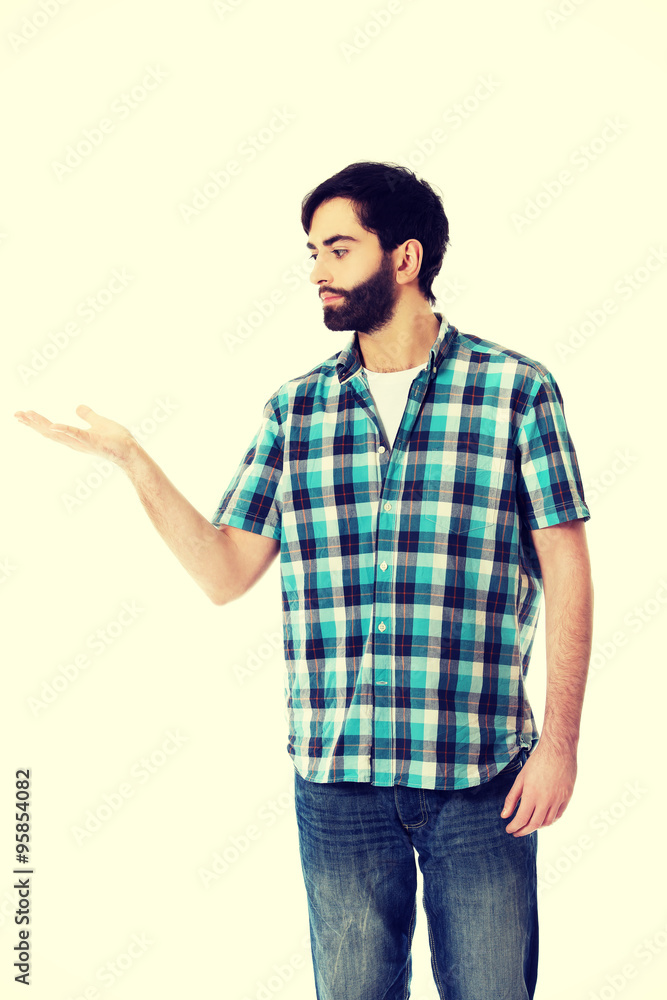 Young man showing something on palm. Young man showing something on palm.