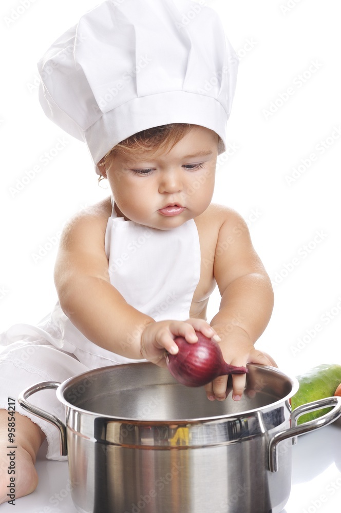 Funny adorable baby boy chef sitting and playing with kitchen equipment Funny adorable baby boy chef sitting and playing with kitchen equipment