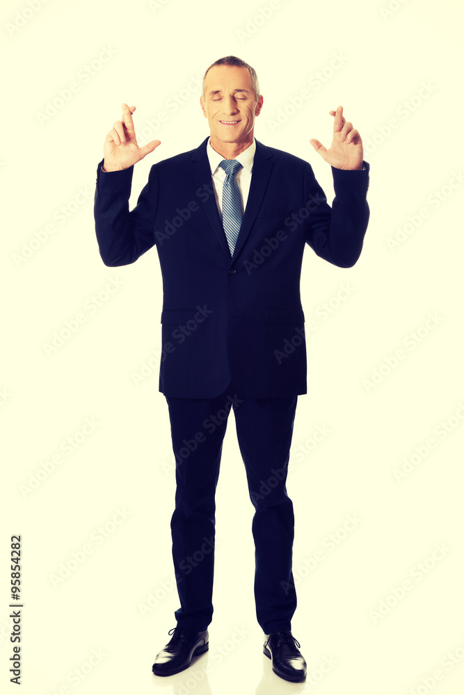 Businessman making a wish with fingers crossed Businessman making a wish with fingers crossed