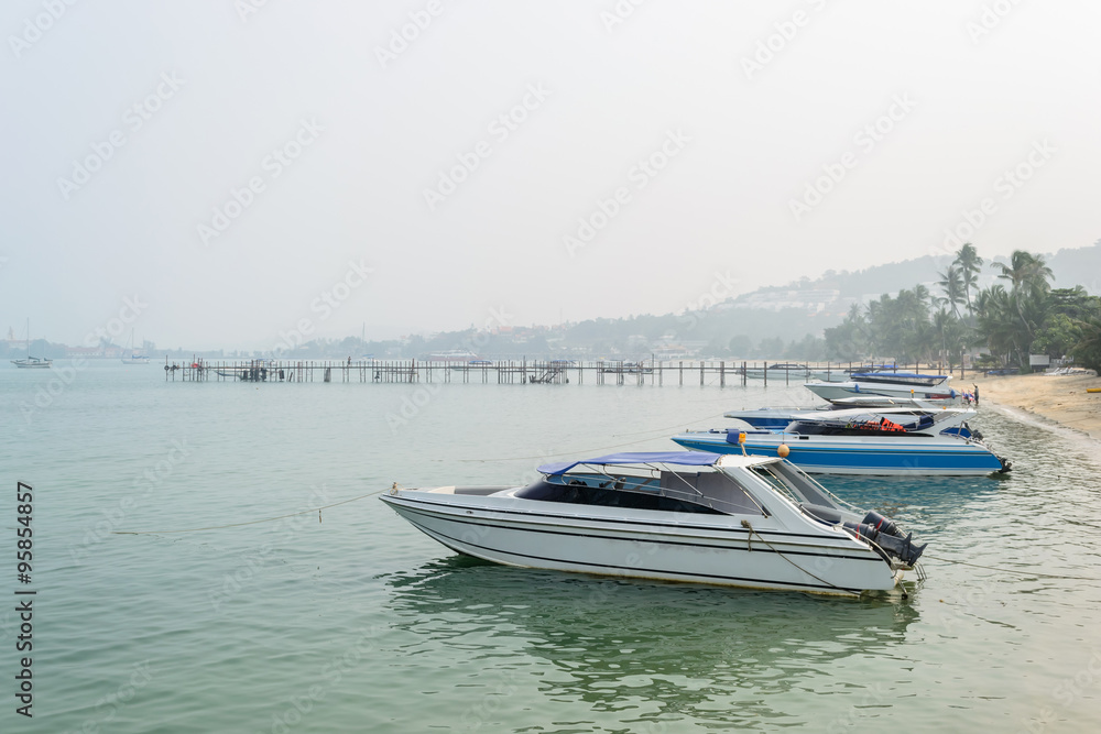 Speed Boats moored on tropical sea in Samui Island,Thailand with foggy sky.