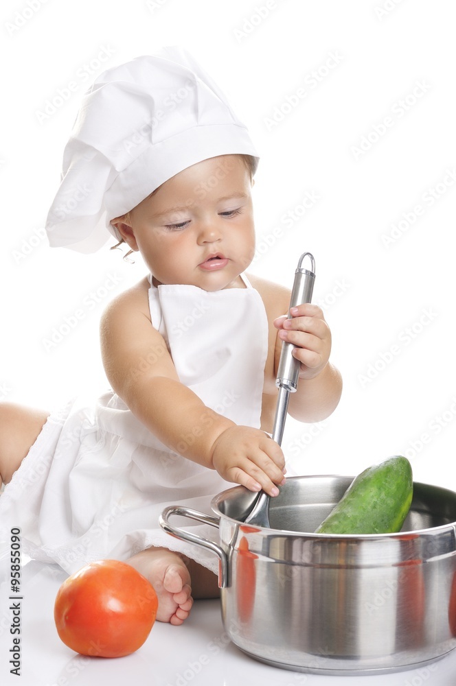 Funny adorable baby boy chef sitting and playing with kitchen equipment Funny adorable baby boy chef sitting and playing with kitchen equipment
