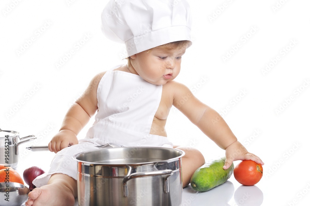 Funny adorable baby boy chef sitting and playing with kitchen equipment Funny adorable baby boy chef sitting and playing with kitchen equipment