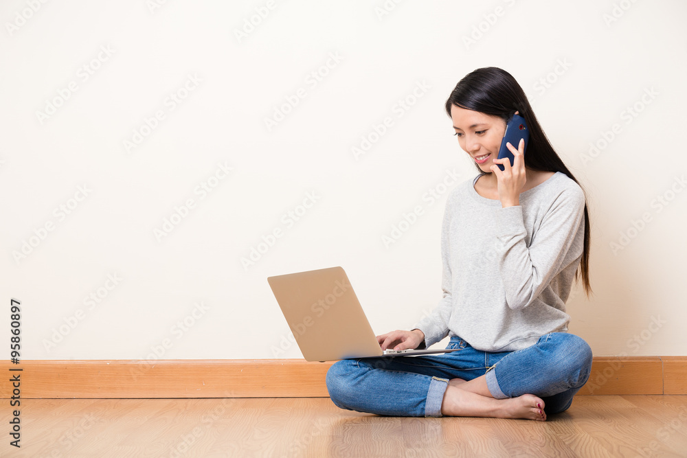 Woman talk to someone by mobile phone with watch on the laptop c Woman talk to someone by mobile phone with watch on the laptop c