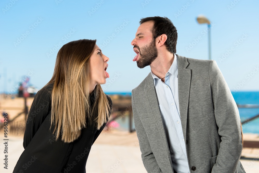 Couple sticking out her tongue over white background Couple sticking out her tongue over white background