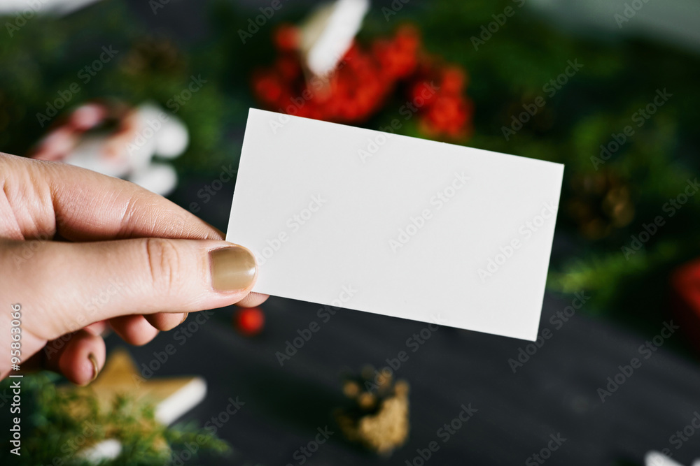 Blank business card in hand on a New Year's background Blank business card in hand on a New Year's background