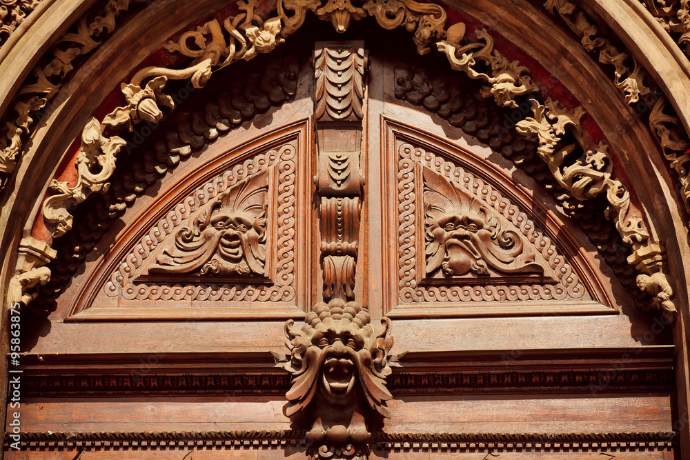 Obraz premium Decorative molding and carved wood with faces on the facade of house