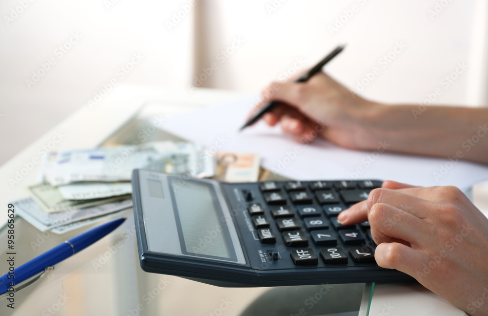 Accounting concept.Analyzing finance report with calculator Accounting concept.Analyzing finance report with calculator