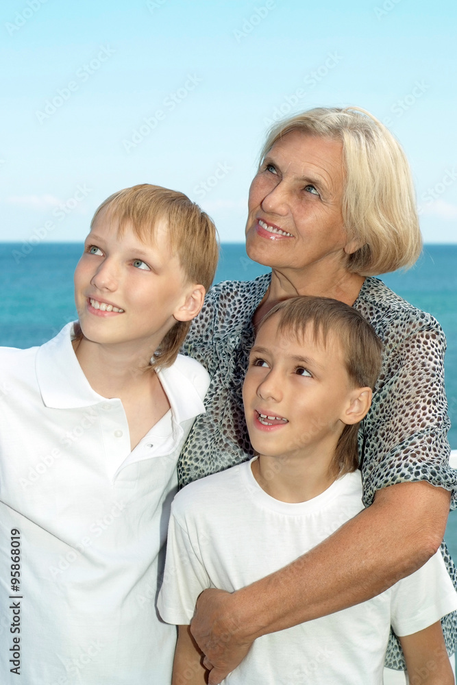 elderly woman with grandsons on beach elderly woman with grandsons on beach