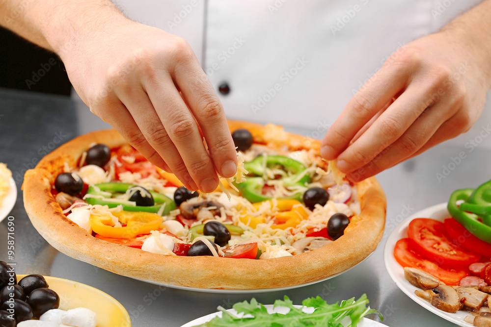 Cook making delicious pizza at the restaurant, close-up